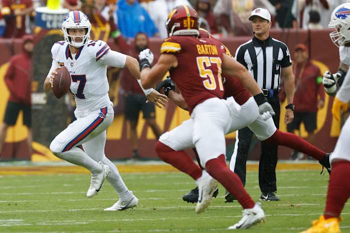 Buffalo Bills quarterback Josh Allen runs with the ball in a game against the Washington Commanders.